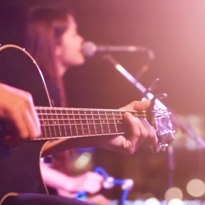 person playing guitar and woman singing