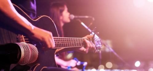 person playing guitar and woman singing
