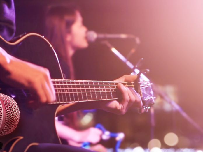 person playing guitar and woman singing