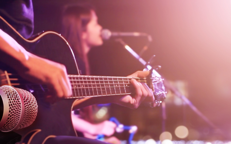 person playing guitar and woman singing