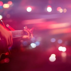 a musician playing a guitar at a bar