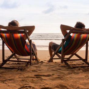 Romantic couple sitting in deck chairs thinking about kiawah island vs. isle of palms