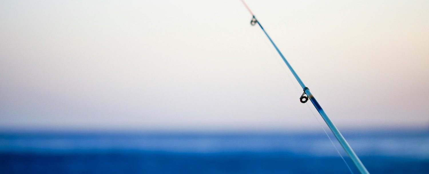 fishing pole in front of the ocean; surf fishing on Isle of Palms