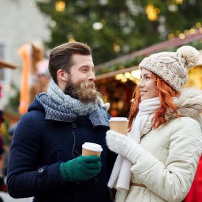 happy couple drinking coffee on old town street