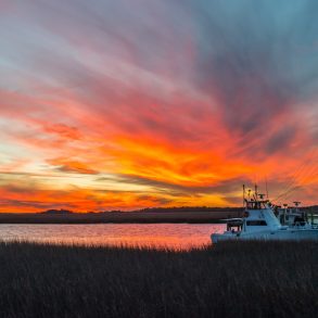 Boat on Isle of Palms marina at sunset.