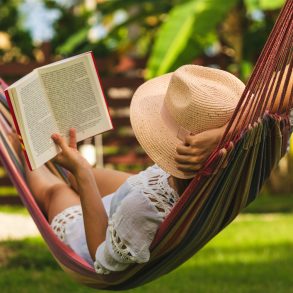 Woman reading a book in a hammock.