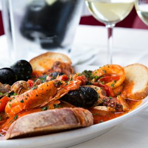 Horizontal sea food tomatoes mediterranean soup with bread and glass of white wine
