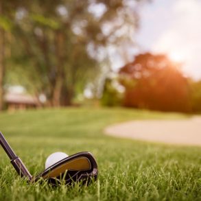 Person teeing off at a golf course.