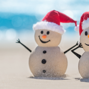 snowmen with Santa hats on beach