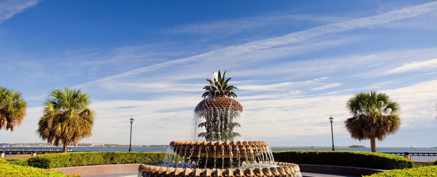 Pineapple fountain on a day with few clouds and a blue sky in downtown Charleston