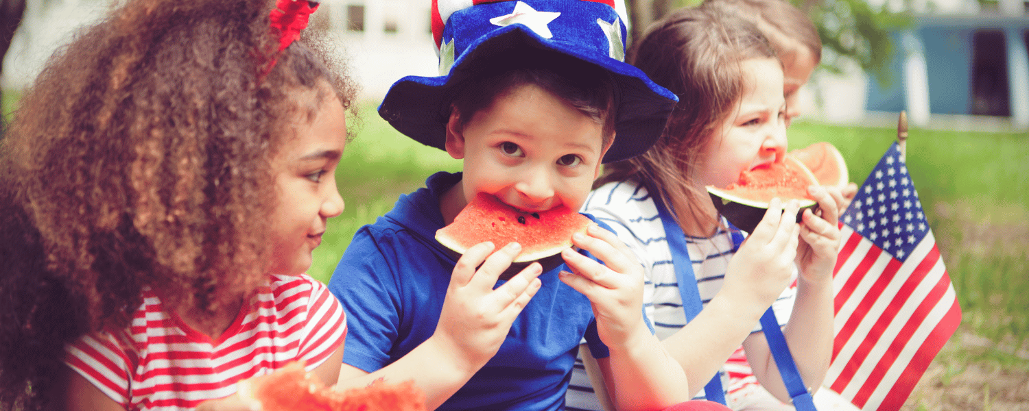 children wearing patriotic attire and eating watermelon