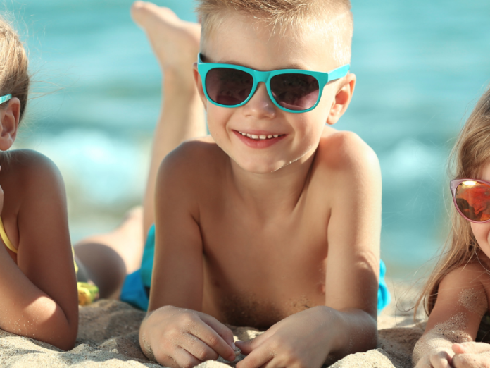 three kids on beach with sunglasses
