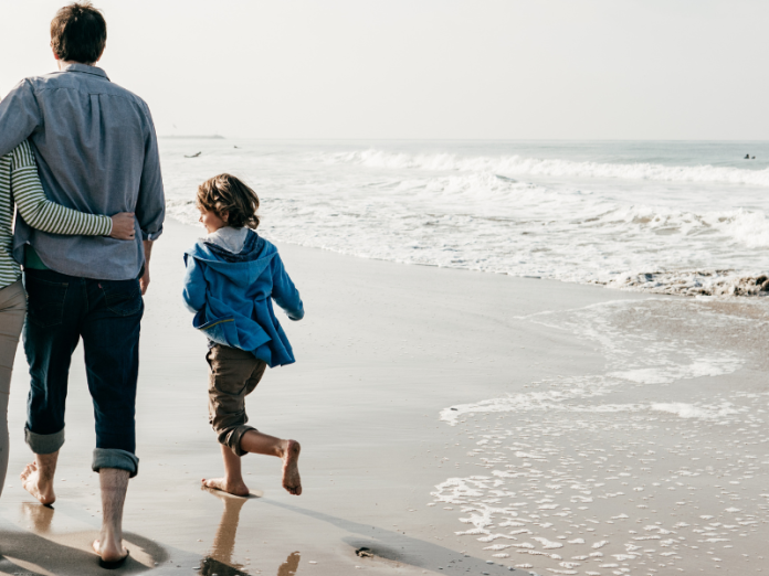 family of four walking on the beach