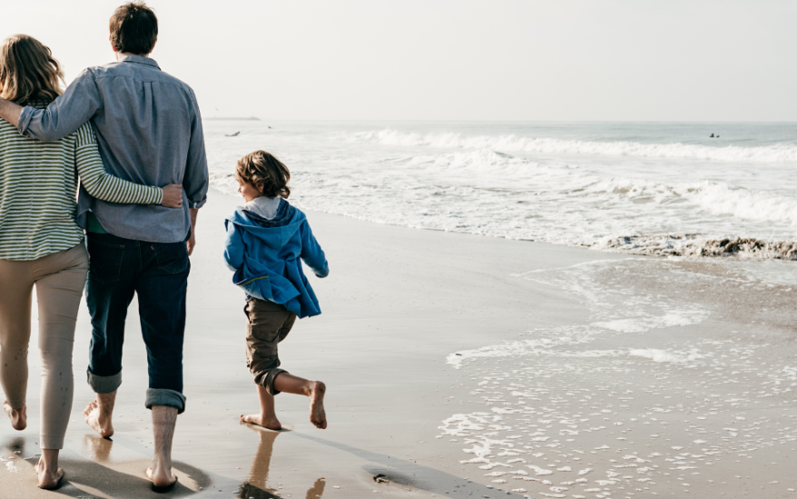 family of four walking on the beach