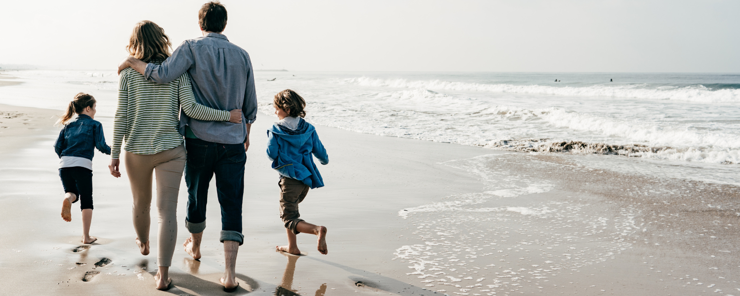 family of four walking on the beach