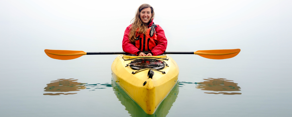 woman in yellow kayak wearing a red jacket