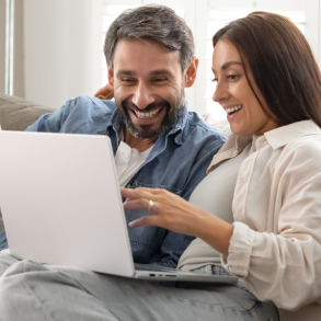 couple sitting on couch looking at computer