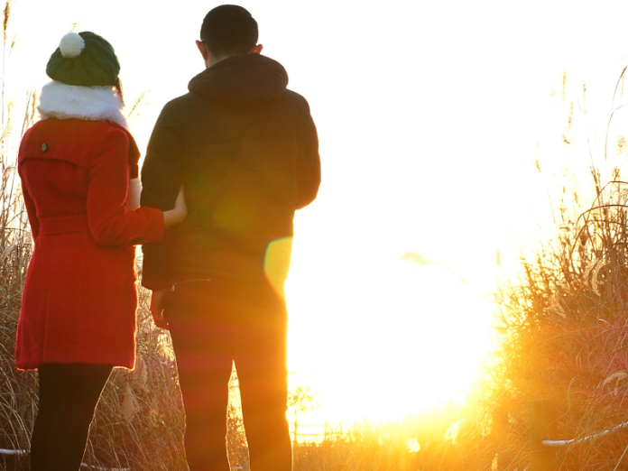 couple overlooking sunrise in winter