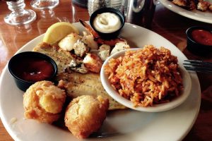 A southern seafood platter of grilled shrimp, fish and scallops with hushpuppies and red rice near Charleston, South Carolina, in the heart of the lowcountry.