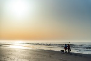 Girls with their dog strolling along the beach in Isle of Palms, SC.