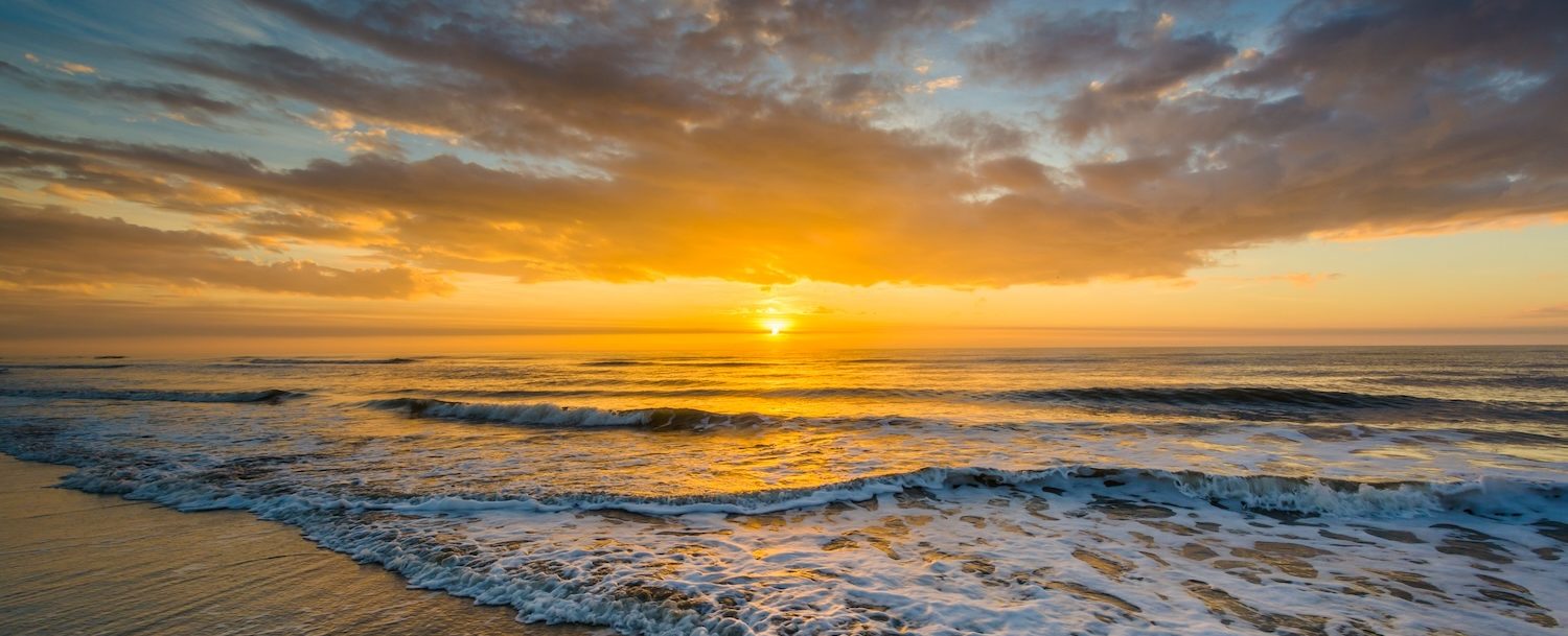 Waves in the Atlantic Ocean and sunrise, in Isle of Palms, South Carolina.