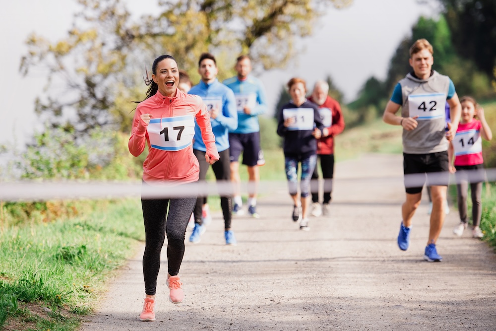 A large group of active people running a race competition in nature. 