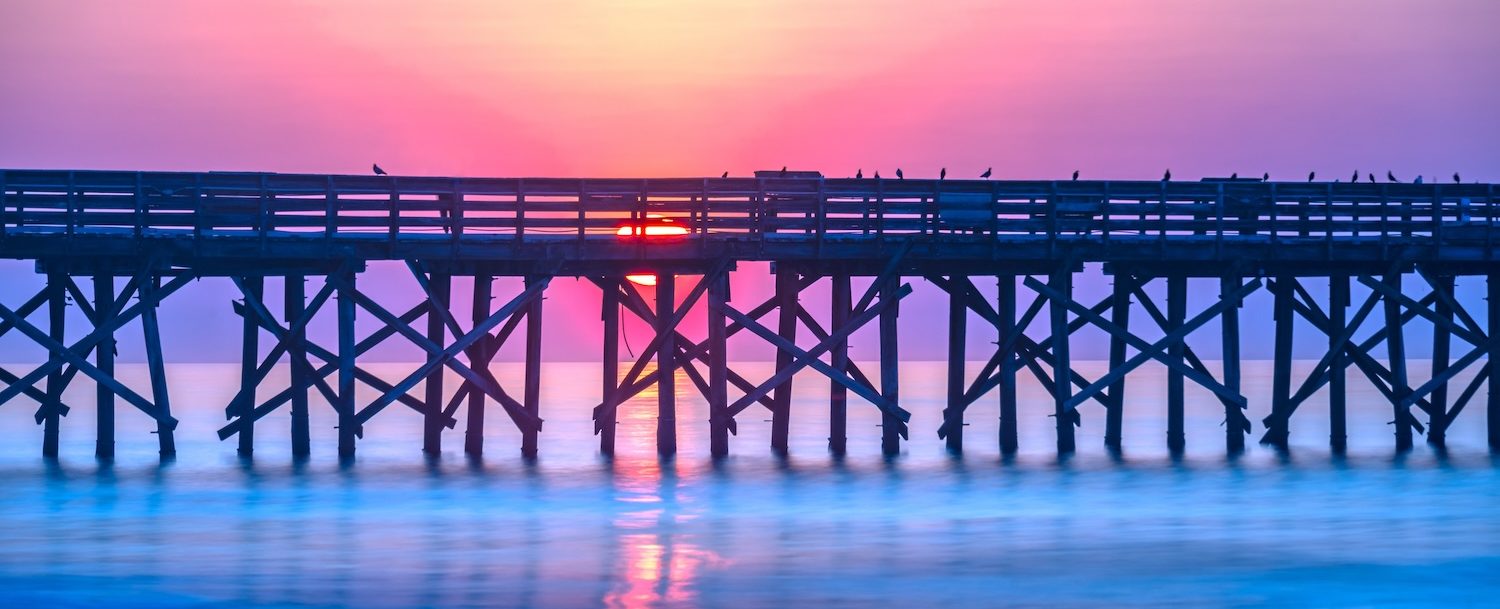 Sunrise over the pier at Isle of Palms, SC, USA.