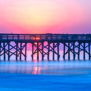 Sunrise over the pier at Isle of Palms, SC, USA.