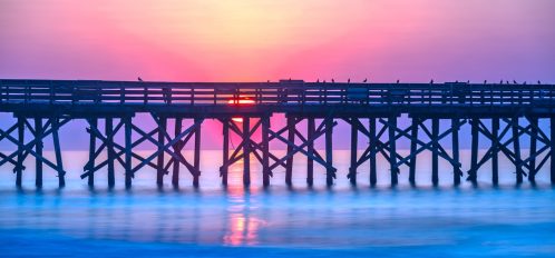 Sunrise over the pier at Isle of Palms, SC, USA.